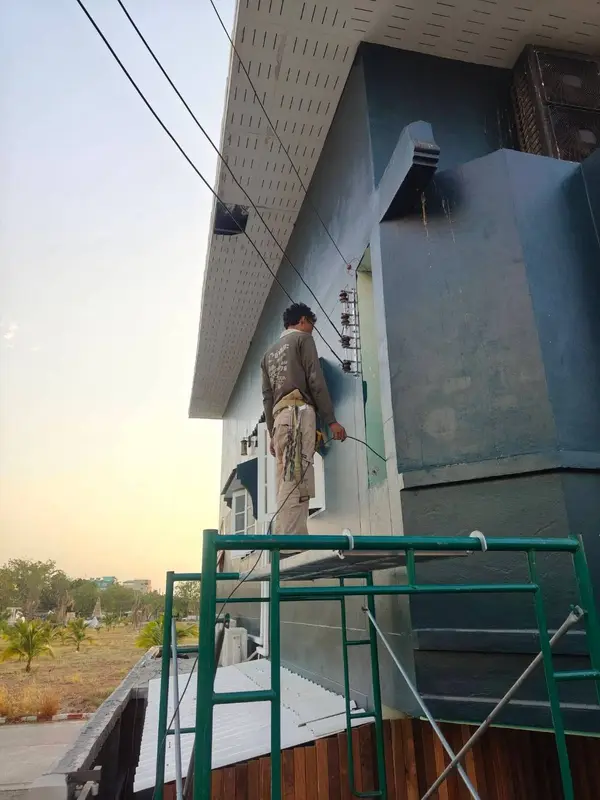 ทีมช่างก่อสร้างทำงานภายนอกอาคารบนนั่งร้าน